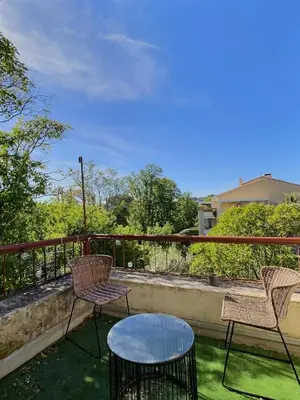a patio with two chairs and a table on a balcony at Studio centre Aix - Climatisé avec terrasse in Aix-en-Provence