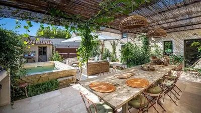 a patio with a table and a swimming pool at A typical provençal house in Mollégès