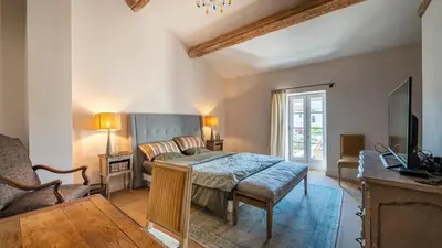 a bedroom with a bed and a living room at A typical provençal house in Mollégès
