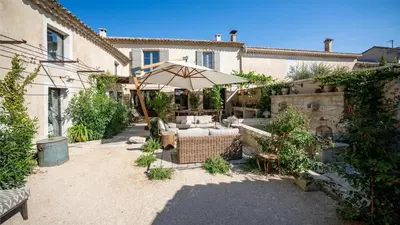 an outdoor patio with an umbrella and furniture in a courtyard at A typical provençal house in Mollégès