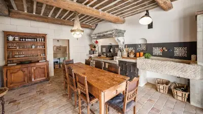 a large kitchen with a wooden table in a room at A typical provençal house in Mollégès