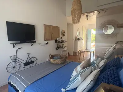 a bedroom with a blue bed with a tv on the wall at Suite privée tout confort in Gargas