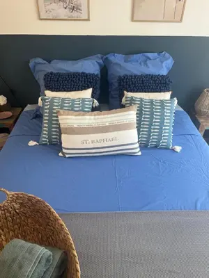 a blue bed with a pile of pillows on it at Suite privée tout confort in Gargas