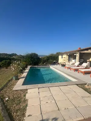 a swimming pool with chairs and a house at Suite privée tout confort in Gargas