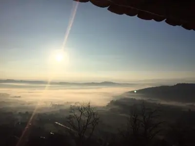 a view of the sun rising over a foggy valley at L'oustau étoilé in Gordes