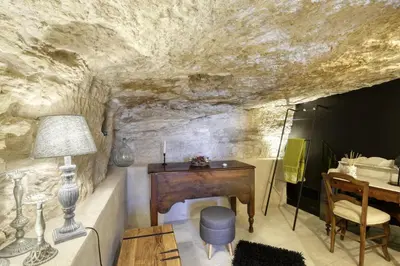 a room with a table and a desk in a cave at L'oustau étoilé in Gordes