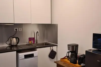 a kitchen with white cabinets and a counter top at Havre de paix au coeur historique in Aix-en-Provence