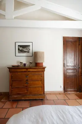 a bedroom with a wooden dresser with a lamp on it at Spacious villa in Provence in Le Puy-Sainte-Réparade