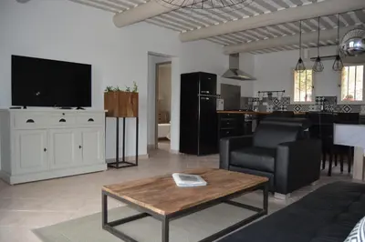 a living room with a tv and a couch and a table at mas des oliviers in Gordes