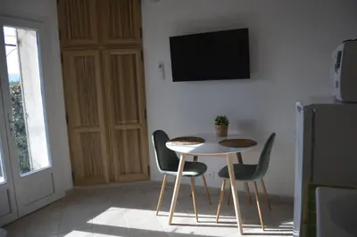 a table and chairs in a room with a tv at mas des oliviers in Gordes