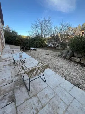 two benches and a table on a stone patio at Appartement dans Aix-en-Provence - Sainte Victoire in Saint-Marc-Jaumegarde