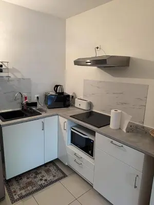 a kitchen with white cabinets and a sink and a stove at Appartement dans Aix-en-Provence - Sainte Victoire in Saint-Marc-Jaumegarde