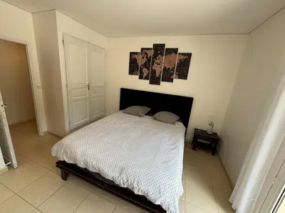 a bedroom with a white bed with a black headboard at Appartement dans Aix-en-Provence - Sainte Victoire in Saint-Marc-Jaumegarde