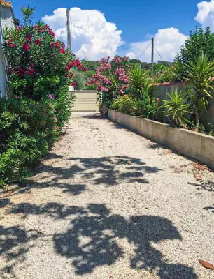 a driveway with pink flowers and a garage at Studio Velaux in Velaux