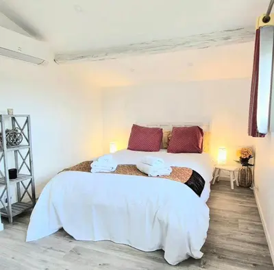 a bedroom with a large bed with towels on it at Villa grand confort, piscine privée, petanque, pool house in Alleins