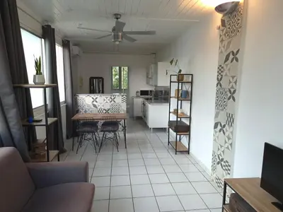 a living room with a table and a kitchen at Provence Studio 33 m2 in Cavaillon