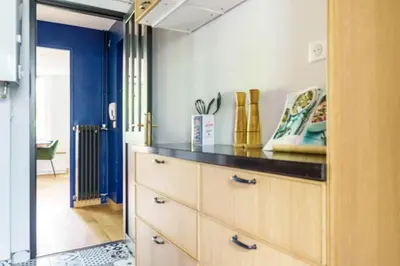 a kitchen with wooden cabinets and a blue wall at T4 Aix PARKING CLIM refait a neuf in Aix-en-Provence