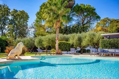 a pool with a statue next to a palm tree at Villa Valleron by Villa Plus in Saint-Saturnin-les-Avignon