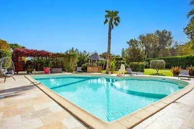 a swimming pool in a yard with a palm tree at Villa Valleron by Villa Plus in Saint-Saturnin-les-Avignon