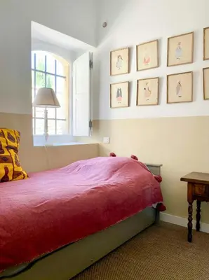 a bedroom with a red bed and a window at Stone House Within Castle Ramparts In Goult in Goult
