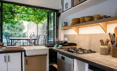 a kitchen with a sink and a stove top oven at Stone House Within Castle Ramparts In Goult in Goult