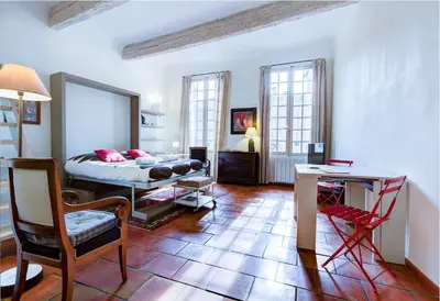 a bedroom with a bed and a table and chairs at Aude Loft in Aix-en-Provence