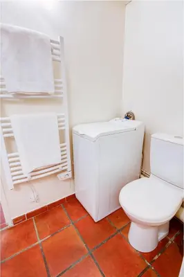 a bathroom with a white toilet and a red tile floor at Aude Loft in Aix-en-Provence