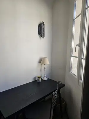 a desk in a room with a lamp and a window at Duplex entre Palais de justice et Cours Mirabeau, Climatisation in Aix-en-Provence