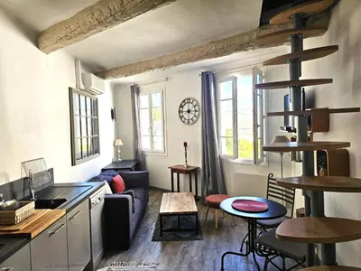 a kitchen and living room with a couch and a table at Duplex entre Palais de justice et Cours Mirabeau, Climatisation in Aix-en-Provence