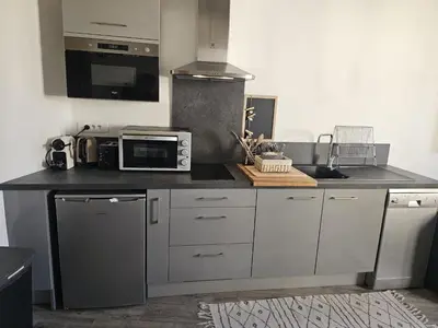 a kitchen with a counter with a microwave and a stove at Duplex entre Palais de justice et Cours Mirabeau, Climatisation in Aix-en-Provence