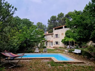 a house with a swimming pool in front of it at agréable séjour en Luberon in Puget