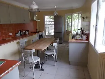 a kitchen with a wooden table and chairs in it at agréable séjour en Luberon in Puget