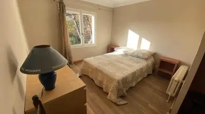 a bedroom with a bed and a lamp on a table at agréable séjour en Luberon in Puget