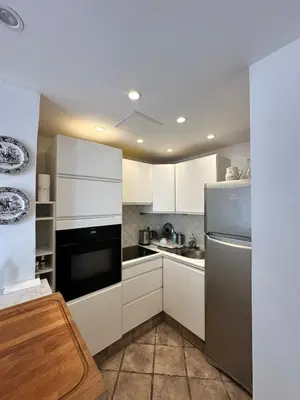 a kitchen with white cabinets and a stainless steel refrigerator at - Élégant cocon au cœur du centre historique - in Aix-en-Provence