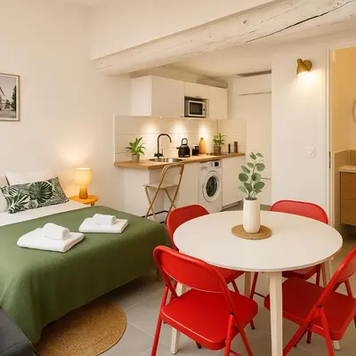 a room with a table and chairs and a kitchen at T2 Duplex climatisé Suite et canapé-lit Aix centre in Aix-en-Provence