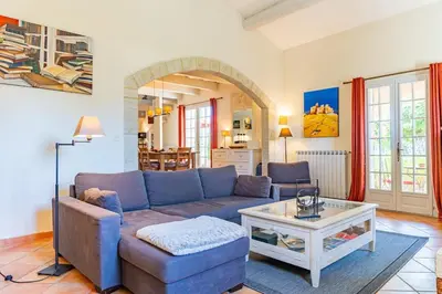 a living room with a blue couch and a table at Villa A l'ombre du Géant climatisée piscine pour 8 personnes in Saint-Pierre-de-Vassols