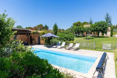 a swimming pool in a yard with chairs and a house at Villa A l'ombre du Géant climatisée piscine pour 8 personnes in Saint-Pierre-de-Vassols