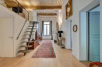 a hallway with a spiral staircase and a rug at Beautiful duplex, historic center, private garden in Aix-en-Provence