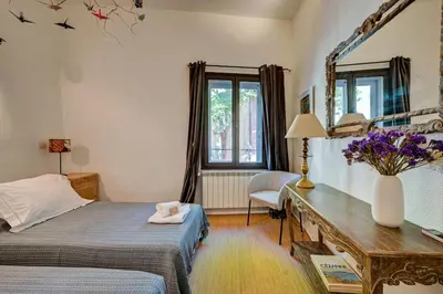 a bedroom with a bed and a desk and a mirror at Beautiful duplex, historic center, private garden in Aix-en-Provence