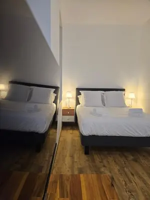 two beds in a small room with two lamps at La Bastide Foch - Appart'Hôtel Calme & Confort Centre Ville in Salon-de-Provence