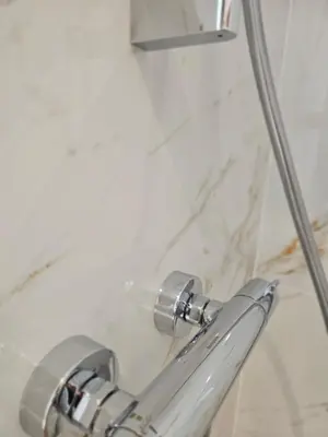 a close up of a shower handle in a bathroom at La Bastide Foch - Appart'Hôtel Calme & Confort Centre Ville in Salon-de-Provence
