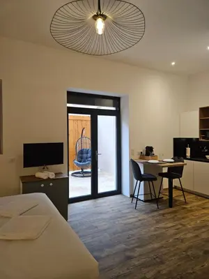 a bedroom with a bed and a table with chairs at La Bastide Foch - Appart'Hôtel Calme & Confort Centre Ville in Salon-de-Provence
