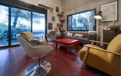 a living room with a couch and chairs and windows at Maison Piscine Proche Alpilles in Noves