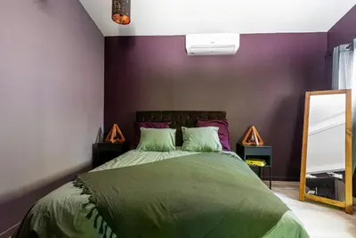 a bedroom with a green bed with purple walls at Modern Loft With Pool Near Lourmarin in Puget