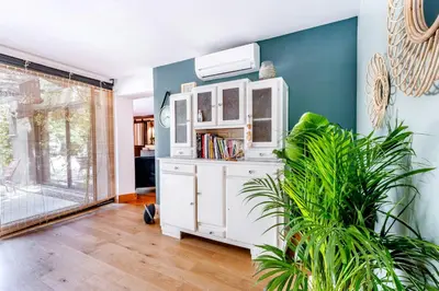 a living room with a white cabinet and a plant at House With Rooftop Terrace And Pool In Lourmarin in Puget