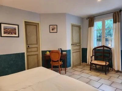 a bedroom with a bed and a dresser and two mirrors at Domaine Les Gendalis in Saint-Saturnin-les-Avignon