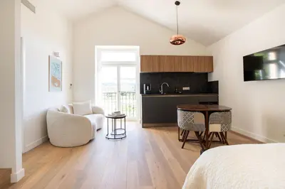 a bedroom with a bed and a table and a kitchen at Grand Cèdre in Aix-en-Provence