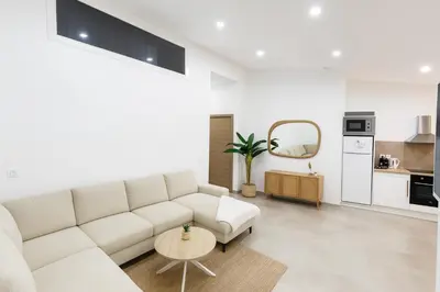 a living room with a white couch and a table at Charmant appartement au centre ville de Cavaillon in Cavaillon