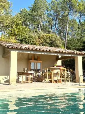 a patio with a table and chairs next to a pool at cheznico jas d la plane in Bédoin