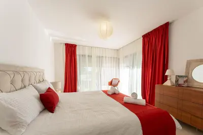 a bedroom with a large bed with red curtains at Aria Blue - Spacieuse - Climatisée - Piscine in Lançon-Provence
